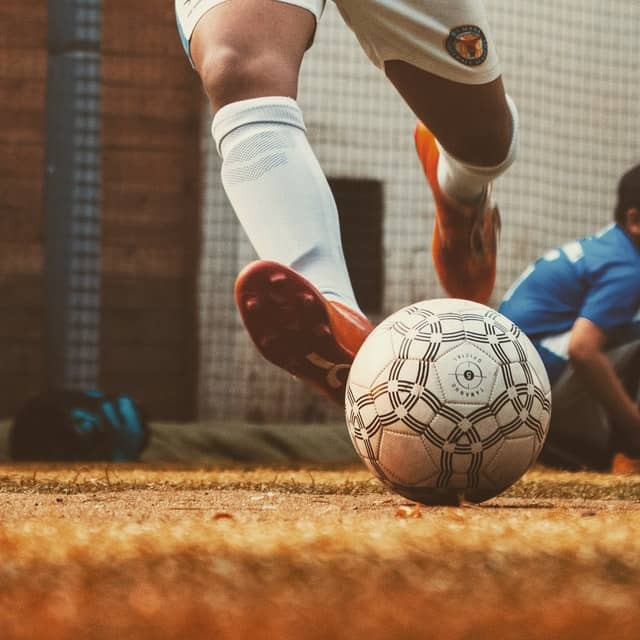 Close up of a soccer player’s legs as he approaches the ball