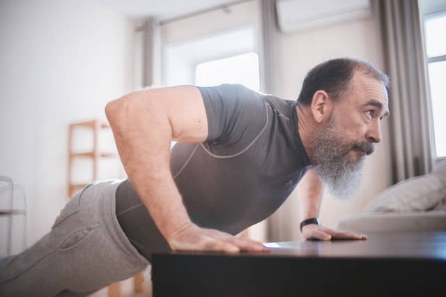 An older man doing push-ups in his home